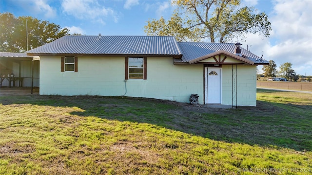 rear view of property featuring a lawn