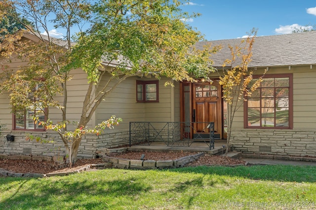 doorway to property with a yard