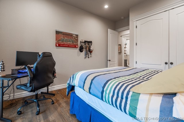 bedroom with dark hardwood / wood-style flooring and a closet