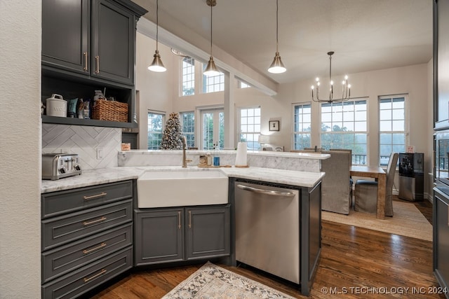 kitchen featuring sink, dark hardwood / wood-style floors, light stone countertops, appliances with stainless steel finishes, and kitchen peninsula