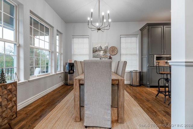 dining space featuring dark hardwood / wood-style floors and an inviting chandelier