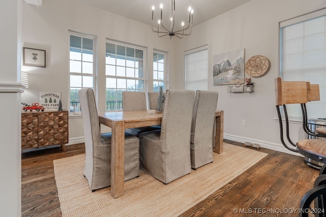 dining space with hardwood / wood-style floors and an inviting chandelier