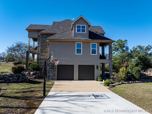 view of front of home with a balcony, a front yard, and a garage