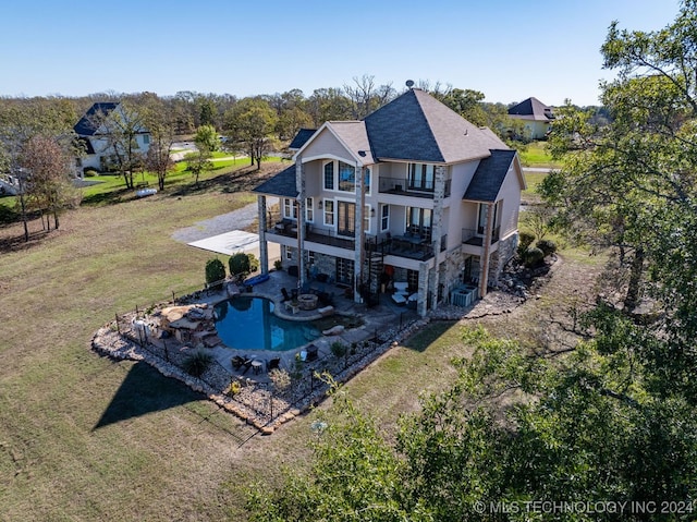 rear view of house with a balcony, a yard, a patio, and central AC