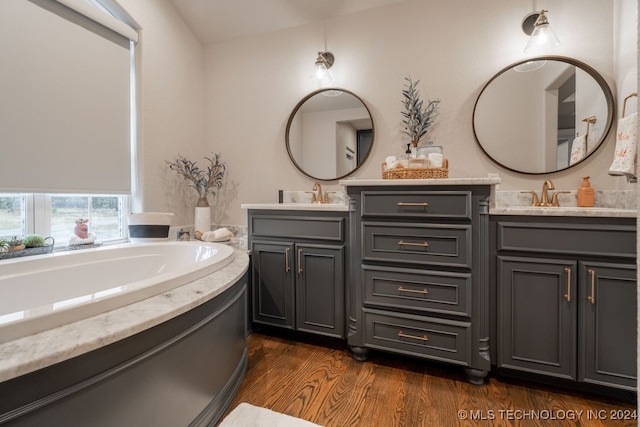 bathroom with hardwood / wood-style floors, vanity, and a bathtub