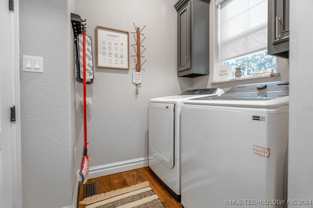 laundry area with washer and dryer, dark hardwood / wood-style flooring, and cabinets