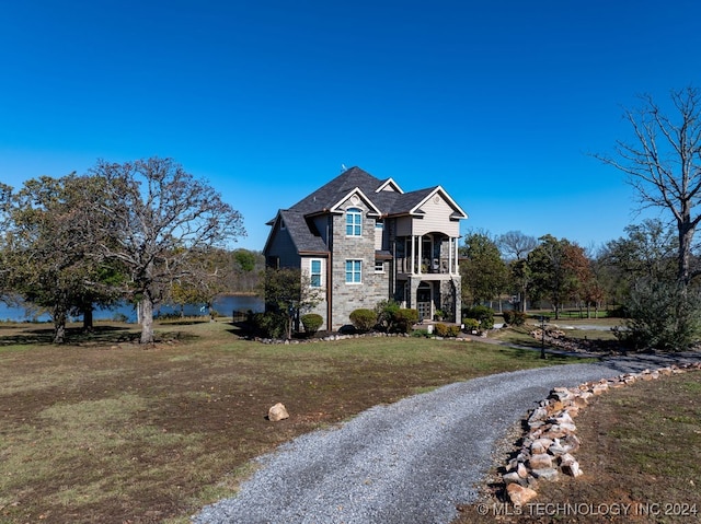 view of front of home featuring a balcony and a front yard