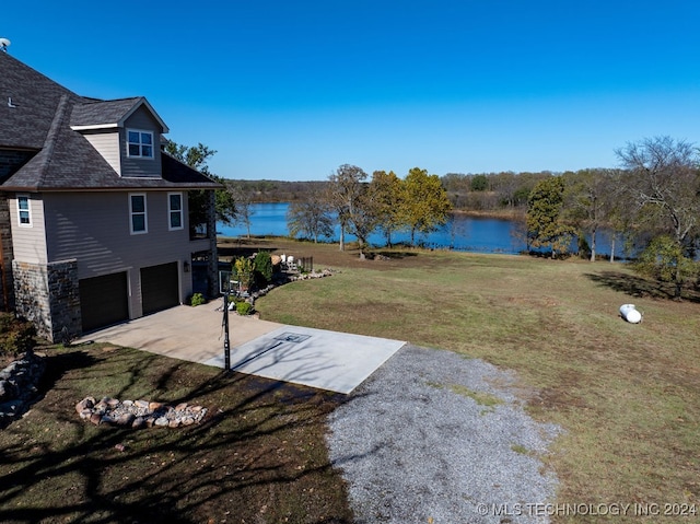 view of yard featuring a water view and a garage