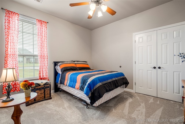 carpeted bedroom with ceiling fan and a closet