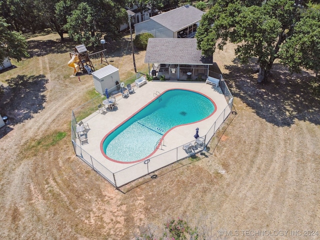 view of pool featuring a playground and a patio