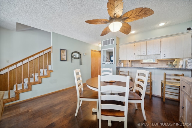 dining area with a textured ceiling, dark hardwood / wood-style floors, and ceiling fan