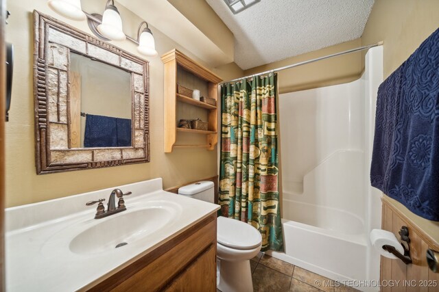 full bathroom featuring tile patterned floors, vanity, a textured ceiling, shower / tub combo with curtain, and toilet