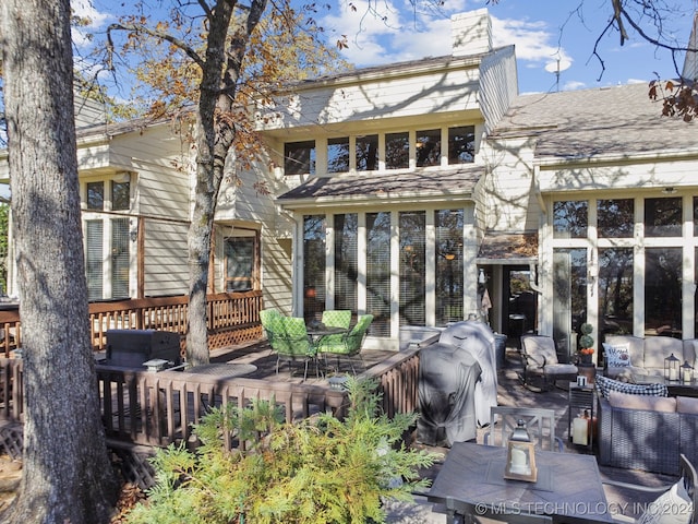 back of property with outdoor lounge area and a deck