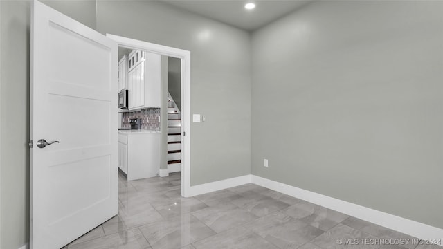 684 Chateau Bnd, Ardmore, OK 73401 - empty room with light marble finish flooring, stairway, and recessed lighting