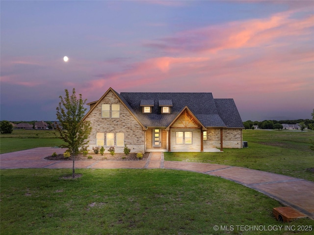 684 Chateau Bnd, Ardmore, OK 73401 - view of front of property with a lawn, stone siding, a shingled roof, and curved driveway