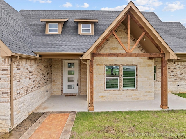 684 Chateau Bnd, Ardmore, OK 73401 - entrance to property featuring a shingled roof, stone siding, and a patio
