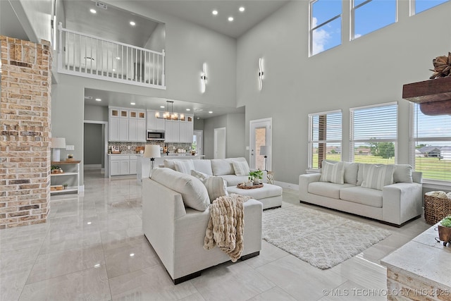 684 Chateau Bnd, Ardmore, OK 73401 - living room with a towering ceiling, a chandelier, plenty of natural light, recessed lighting, and light marble finish flooring