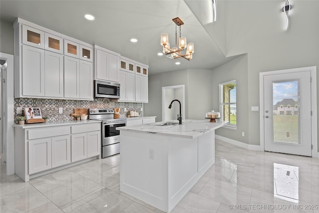 684 Chateau Bnd, Ardmore, OK 73401 - kitchen with stainless steel appliances, light marble finish flooring, recessed lighting, backsplash, and a chandelier