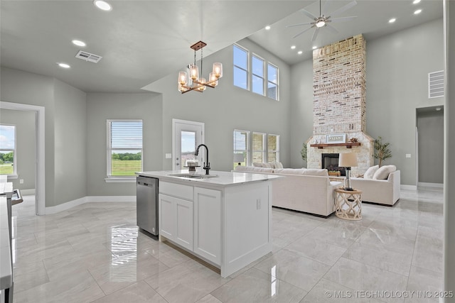 684 Chateau Bnd, Ardmore, OK 73401 - kitchen featuring stainless steel dishwasher, a towering ceiling, light marble finish flooring, a chandelier, and ceiling fan