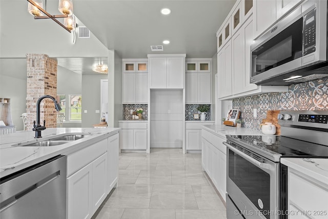 684 Chateau Bnd, Ardmore, OK 73401 - kitchen featuring appliances with stainless steel finishes, light stone counters, light marble finish flooring, tasteful backsplash, and recessed lighting