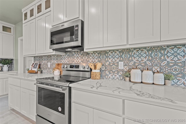 684 Chateau Bnd, Ardmore, OK 73401 - kitchen with appliances with stainless steel finishes, light stone countertops, and white cabinetry