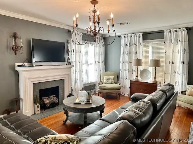 living room featuring a wealth of natural light, hardwood / wood-style floors, and an inviting chandelier