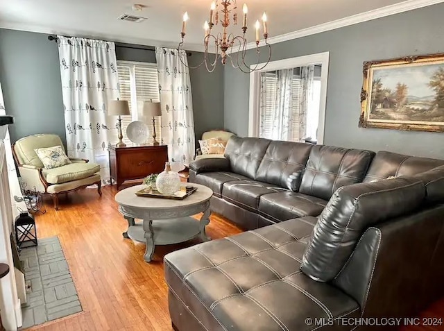 living room featuring light hardwood / wood-style floors, crown molding, and an inviting chandelier