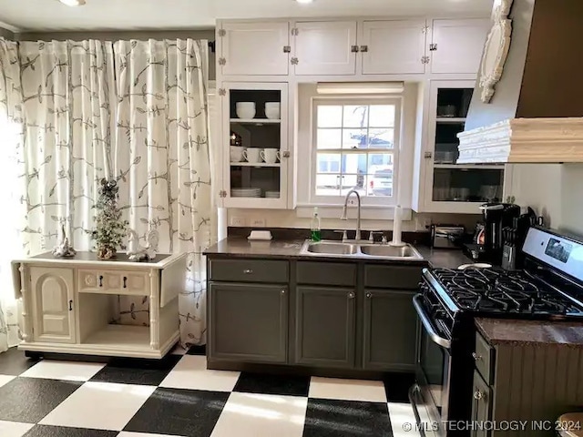 kitchen with white cabinets, gas stove, gray cabinets, and sink