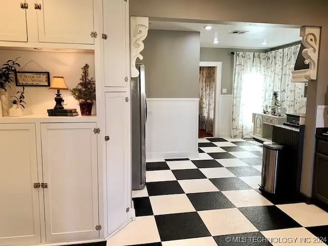 kitchen with white cabinets and stainless steel refrigerator