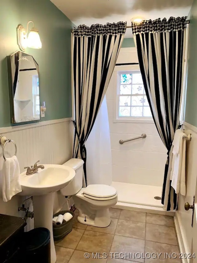 bathroom featuring a shower with shower curtain, tile patterned flooring, and toilet