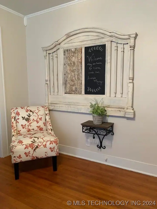 sitting room featuring ornamental molding and hardwood / wood-style flooring