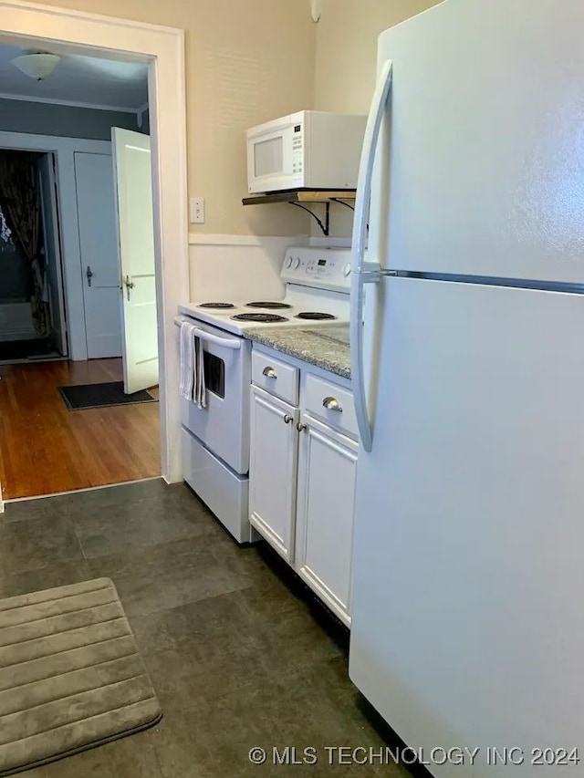 kitchen featuring white cabinetry, dark hardwood / wood-style flooring, and white appliances