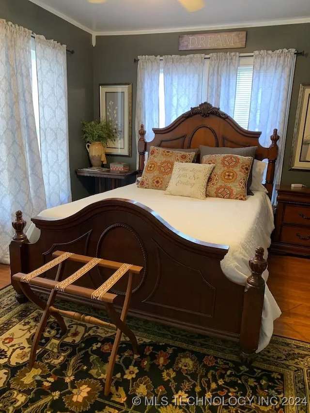 bedroom featuring dark wood-type flooring and crown molding