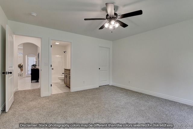 unfurnished bedroom featuring ceiling fan, light colored carpet, and connected bathroom