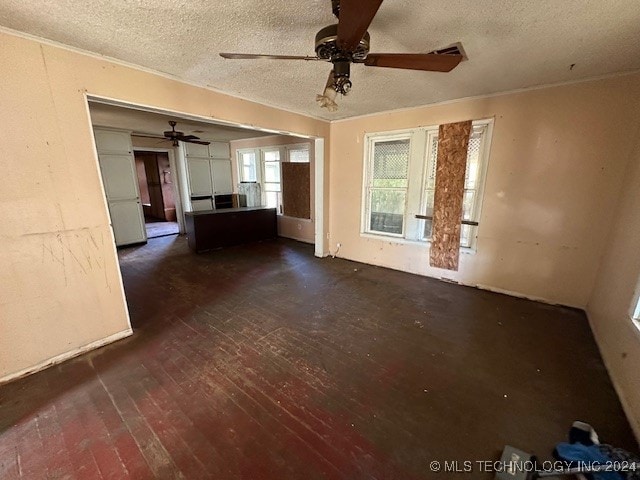 unfurnished living room with a textured ceiling, ceiling fan, and dark hardwood / wood-style floors