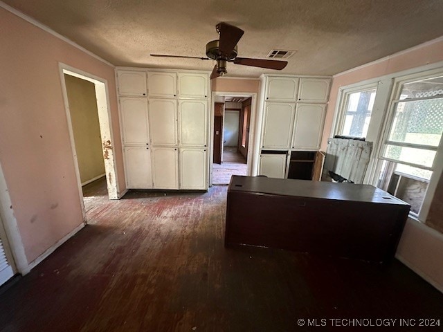 unfurnished office with ceiling fan, dark hardwood / wood-style flooring, crown molding, and a textured ceiling