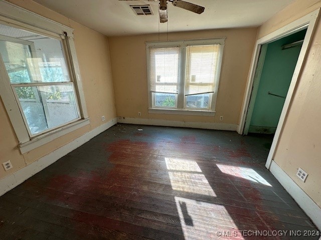 empty room with ceiling fan and dark wood-type flooring