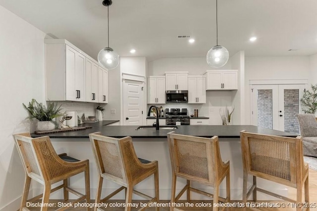 kitchen featuring stainless steel appliances, white cabinets, and a kitchen bar