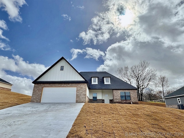 modern farmhouse with brick siding, roof with shingles, concrete driveway, board and batten siding, and a garage