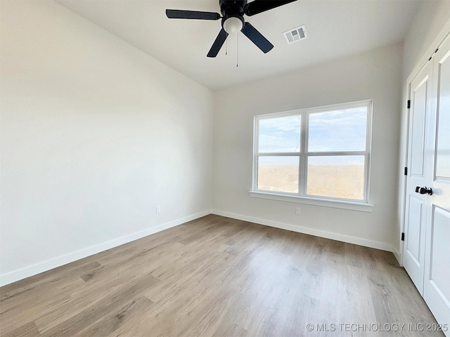 spare room with a ceiling fan, baseboards, visible vents, and light wood finished floors