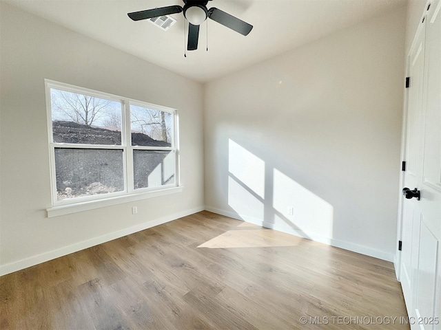 unfurnished room featuring light wood-type flooring, visible vents, baseboards, and a ceiling fan