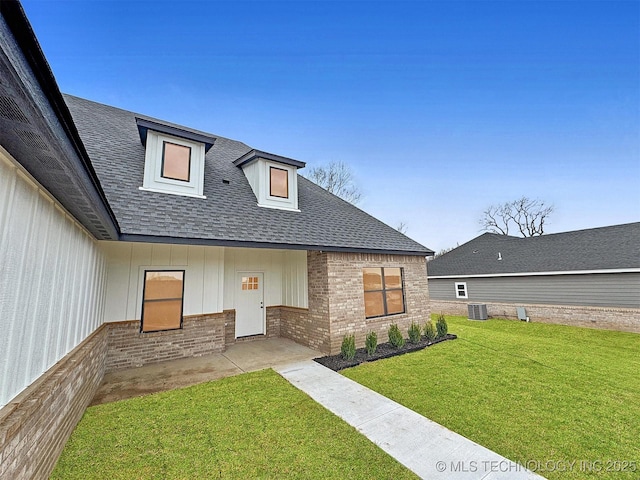 890 E Harlan Dr, Tahlequah, OK 74464 - view of front facade featuring a front yard, roof with shingles, brick siding, a patio, and central AC unit