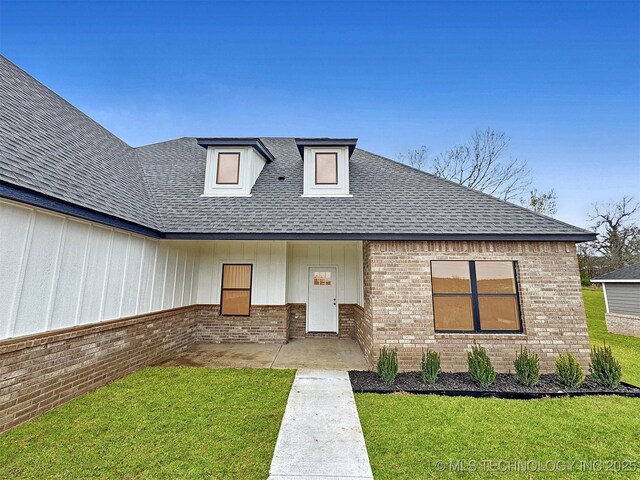 890 E Harlan Dr, Tahlequah, OK 74464 - view of front of home with a shingled roof, board and batten siding, brick siding, and a front yard