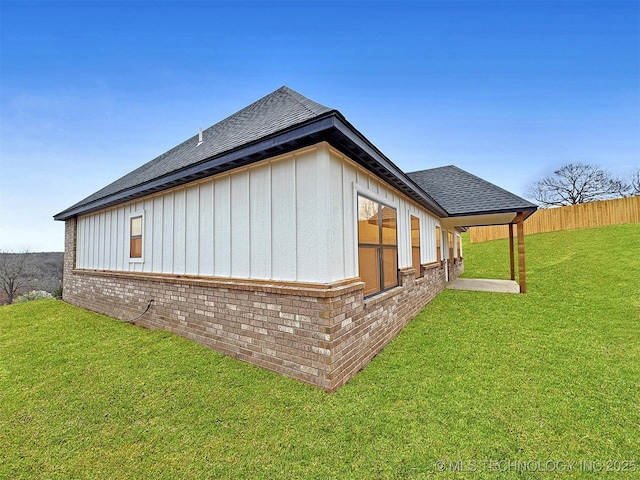 890 E Harlan Dr, Tahlequah, OK 74464 - view of home's exterior with fence, board and batten siding, brick siding, a shingled roof, and a yard