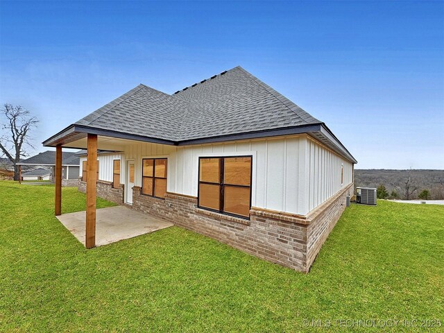 890 E Harlan Dr, Tahlequah, OK 74464 - rear view of property with a patio area, cooling unit, brick siding, a shingled roof, and a yard