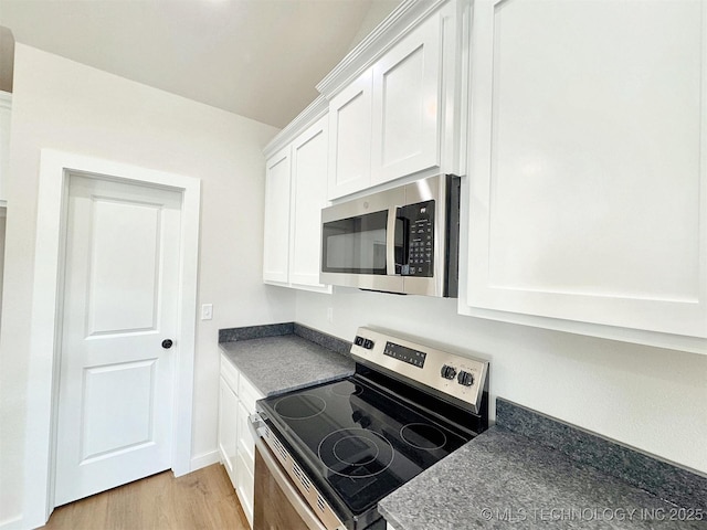 890 E Harlan Dr, Tahlequah, OK 74464 - kitchen with light wood finished floors, dark countertops, white cabinetry, and stainless steel appliances