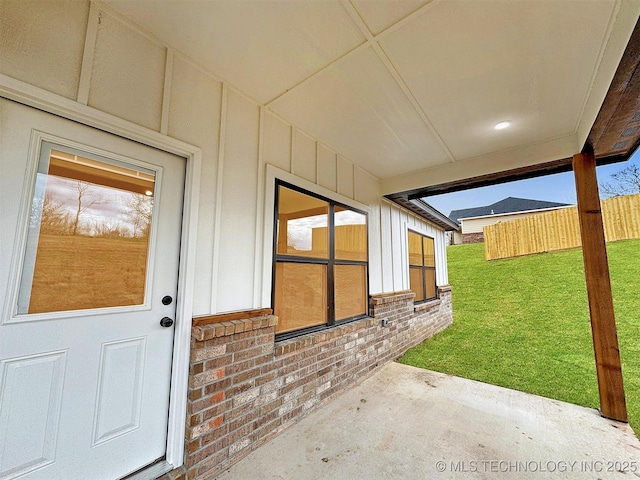 890 E Harlan Dr, Tahlequah, OK 74464 - property entrance featuring a lawn, brick siding, fence, and board and batten siding