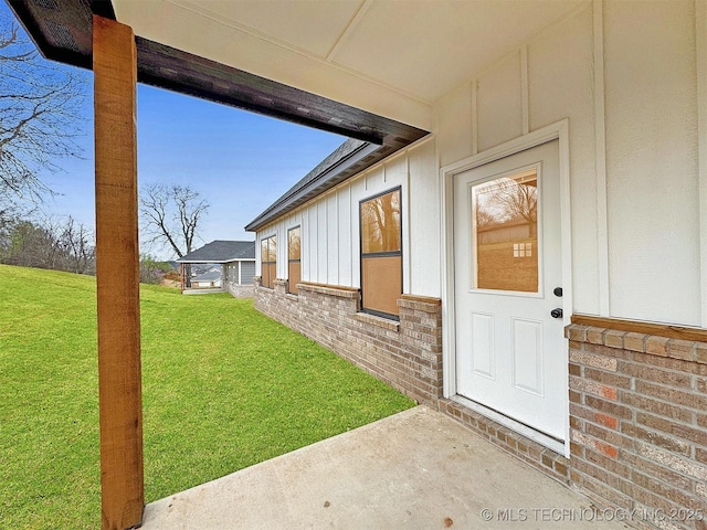 890 E Harlan Dr, Tahlequah, OK 74464 - property entrance with a lawn, board and batten siding, and brick siding