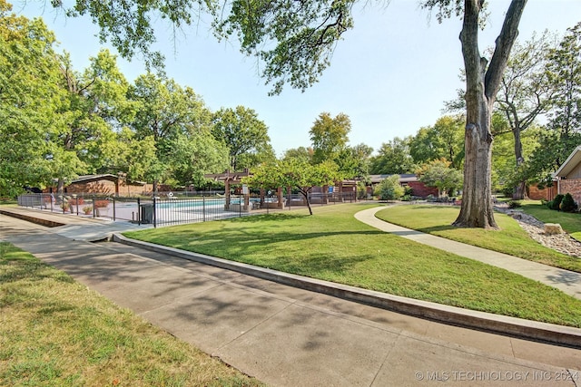 view of community with a lawn and a pool