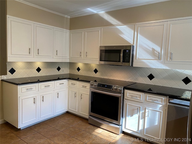 kitchen featuring appliances with stainless steel finishes, tasteful backsplash, white cabinetry, and dark tile patterned floors